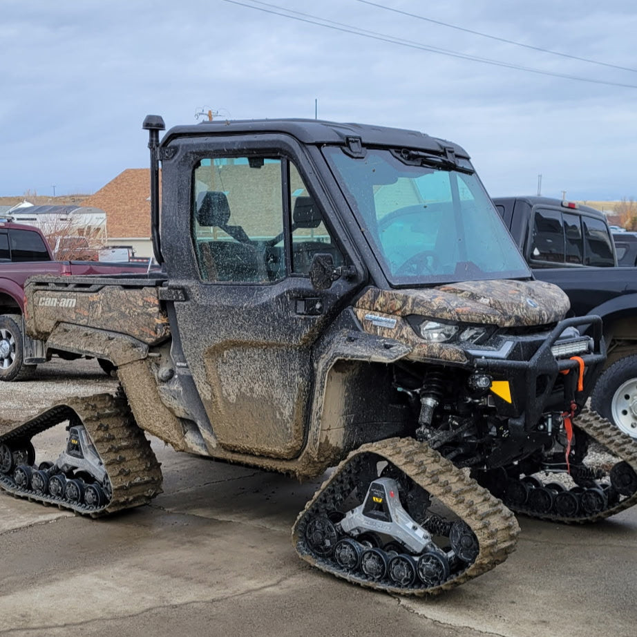 Off-road vehicle with Over the Top Intake on a concrete surface under a cloudy sky.
