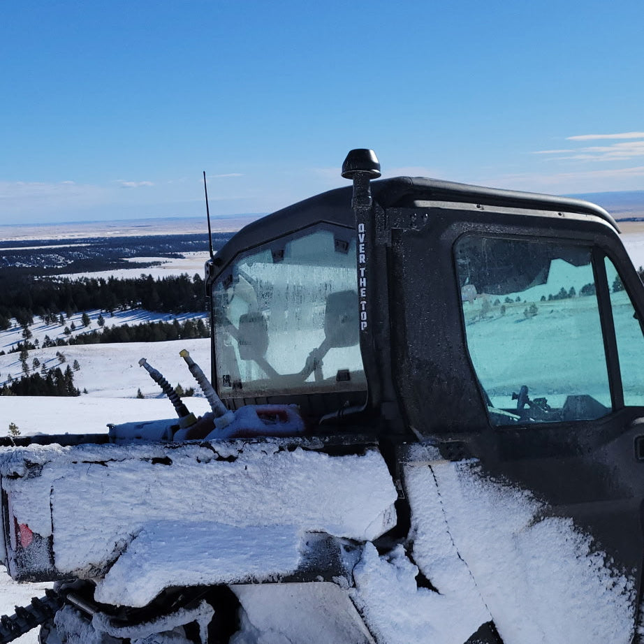 Snow-covered ATV  in a snowy landscape showing Over the Top intake unit.
